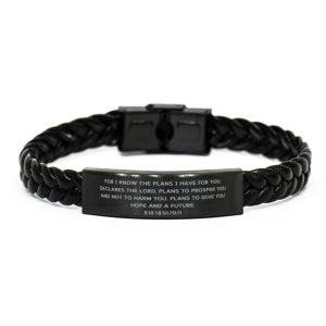 Puede incluir: Pulsera de cuero trenzado negro con cierre de acero inoxidable. La pulsera presenta una placa rectangular con la inscripción "FOR I KNOW THE PLANS I HAVE FOR YOU... HOPE AND A FUTURE. JEREMIAH 29:11".
