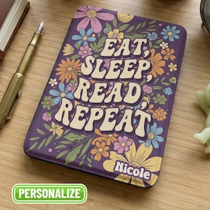 May include: Purple e-reader case with a floral design and the words "EAT, SLEEP, READ, REPEAT" in a retro font. The case is decorated with colorful flowers and green leaves. The name "Nicole" is printed at the bottom. The word "PERSONALIZE" is in a green box.