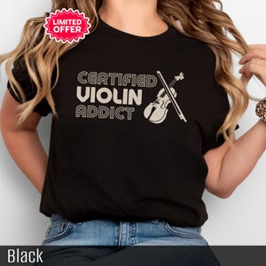 May include: Black t-shirt featuring the text "CERTIFIED VIOLIN ADDICT" and a violin graphic. A "LIMITED OFFER" sticker is in the upper left corner. The word "Black" is at the bottom of the image.
