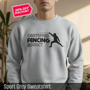 May include: Sport grey sweatshirt with the text "CERTIFIED FENCING ADDICT" and a black silhouette of a fencer. A red and white "25% OFF DISCOUNT" sticker is in the upper left corner.
