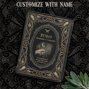 May include: A dark book with gold detailing, inscribed with "Petra's Grimoire of Shadows." The cover design includes skulls, moons, stars, and a hand holding herbs. The text "Customize with Name" is at the top of the book.