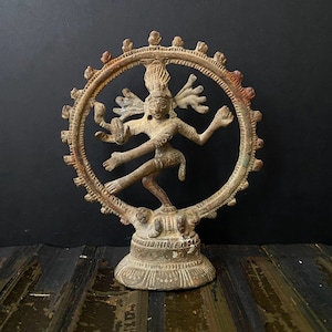 May include: A bronze statue of Shiva Nataraja, the Hindu god of dance, in the traditional pose of cosmic dance. The statue is depicted in a circular frame with a base.