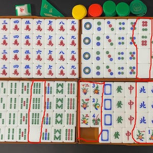 May include: A full Mahjong set, presented in a wooden box, with white tiles marked with Chinese characters and symbols. Includes coloured chips and dice. A traditional board game.
