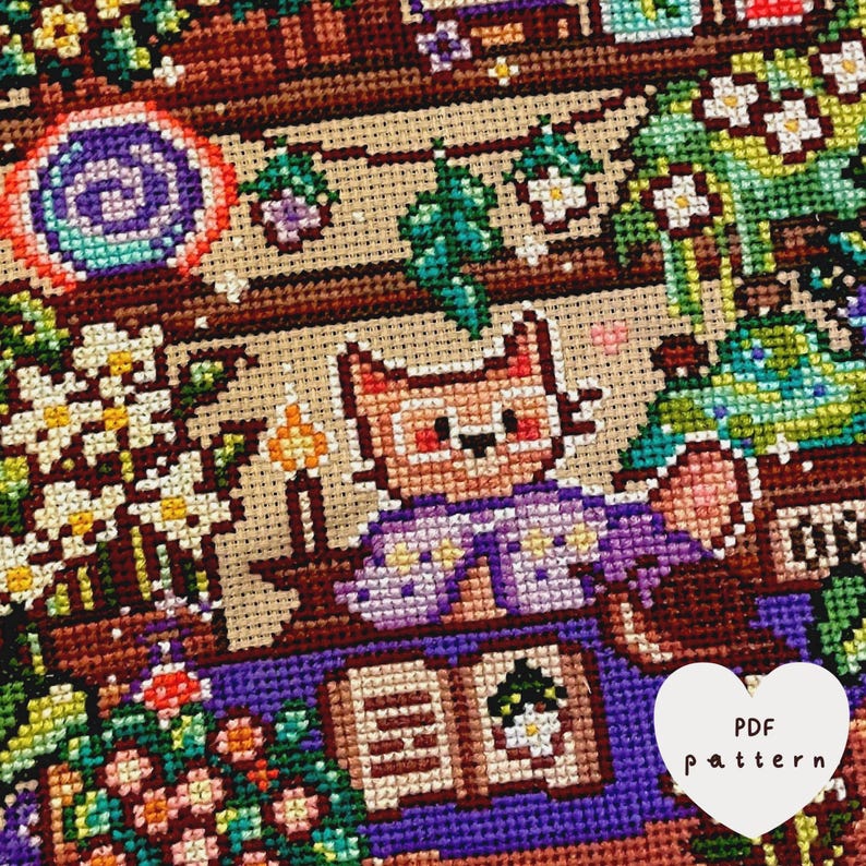 May include: A cross-stitch pattern featuring a cat character in a purple robe, reading a book. The scene includes flowers, candles, and a heart-shaped element with the text "PDF pattern". The color palette includes shades of brown, purple, green, and white.