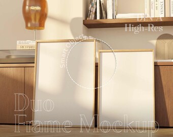May include: Two empty picture frames with a natural wood finish, sitting on a wooden floor. The frames are in a living room setting with a lamp and a bookshelf in the background. The text "DNA High-Res" is visible in the image.