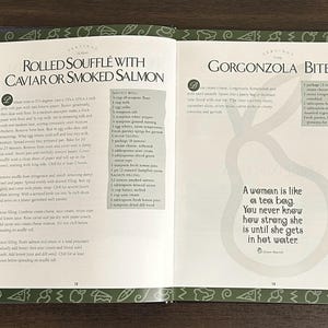 K&ouml;nnte beinhalten: Offene Kochbuchseiten mit Rezepten f&uuml;r gerollte Souffl&eacute;s mit Kaviar oder R&auml;ucherlachs und Gorgonzola-H&auml;ppchen. Die Seiten haben einen gr&uuml;nen Rand mit Illustrationen. Ein Zitat lautet: &bdquo;Eine Frau ist wie ein Teebeutel. Man wei&szlig; nie, wie stark sie ist, bis sie ins hei&szlig;e Wasser kommt.&ldquo;
