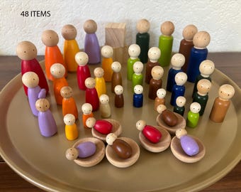 May include: A collection of 48 items consisting of various wooden peg dolls in assorted solid colours including red, orange, yellow, green, blue, purple, and brown, along with several small wooden bowls and two stacked wooden blocks on a tray.