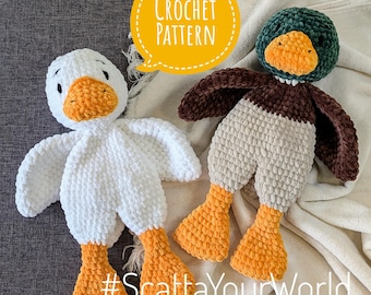 May include: Two crocheted stuffed animals, a white duck and a brown and green duck, with orange feet. The text "#ScattaYourWorld" is on the bottom of the image.