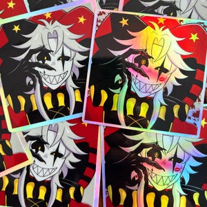 May include: A collection of holographic stickers featuring a cartoon jester character with white hair, a black and white face, and a sinister grin. The jester wears a black and yellow outfit against a red background with gold stars.