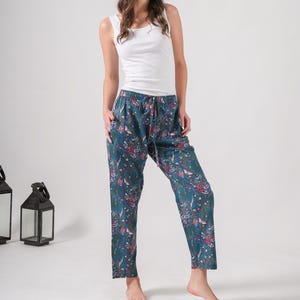 Soft, breathable 100% cotton lounge pants for women featuring vibrant pink floral and butterfly print on blue, with elastic waistband, adjustable drawstring, and deep side pockets.