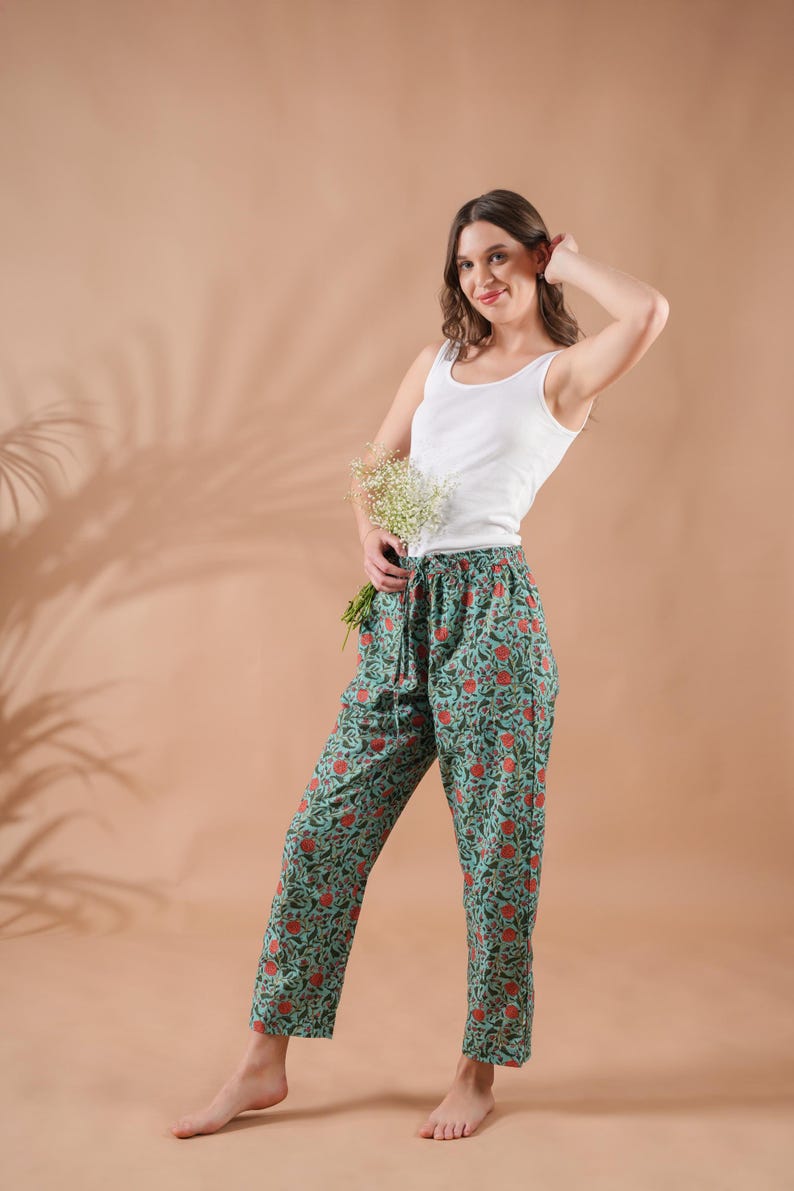 Handmade 100% cotton pajama pants for women with vibrant orange floral print on rich green fabric – breathable, soft, and lightweight lounge pants featuring elastic waistband, adjustable drawstring, and convenient pockets, perfect as relaxed fit pj pants, trendy sleep trousers, or unique menopause gift ideas and cotton anniversary gifts.