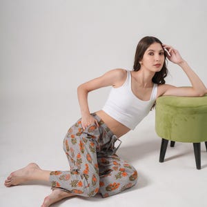 100% cotton pajama pants for women in a modern gray base with vibrant orange floral print – relaxed fit jammies with breathable, lightweight fabric, elastic waistband, adjustable drawstring, and functional side pockets, perfect for tropical lounge & sleepwear or thoughtful menopause gift ideas and cotton anniversary presents.