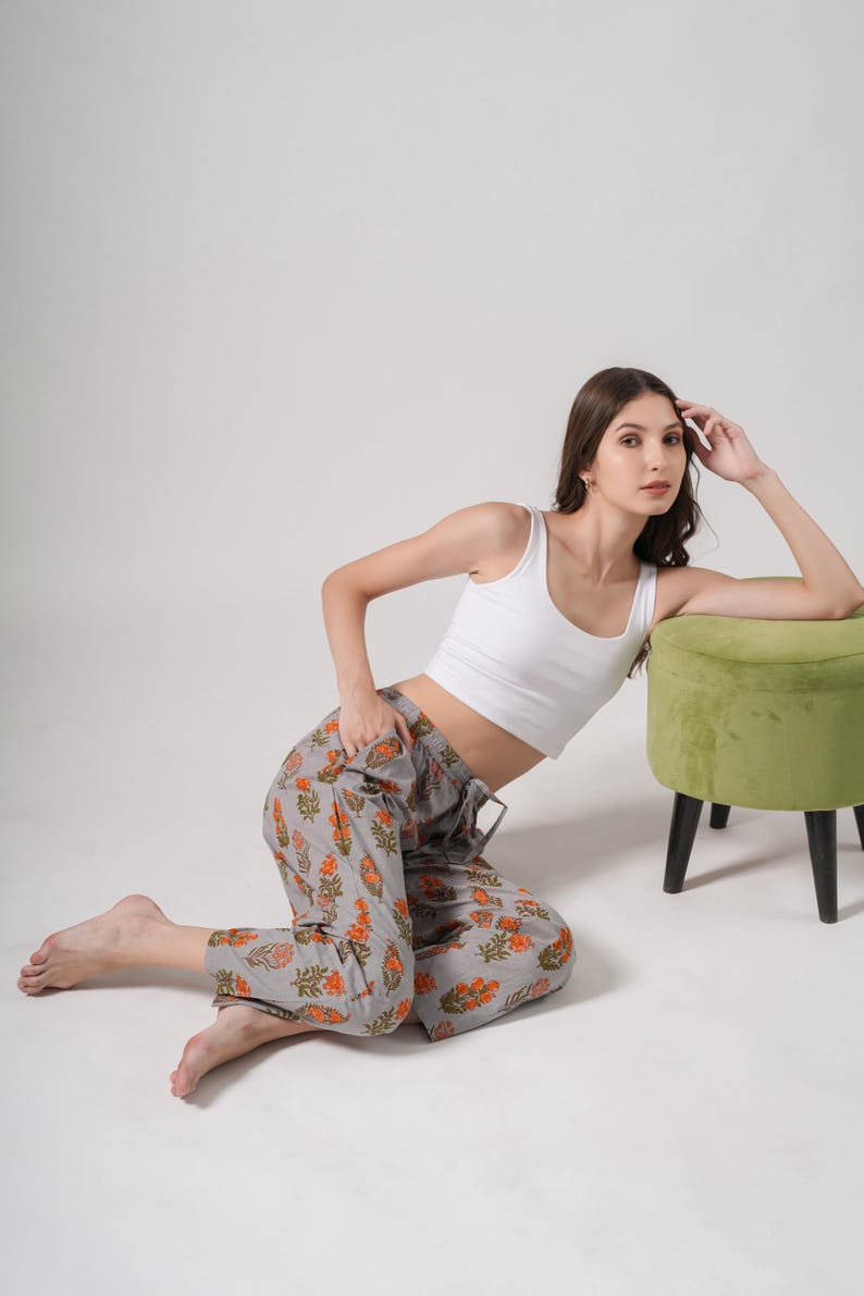100% cotton pajama pants for women in a modern gray base with vibrant orange floral print – relaxed fit jammies with breathable, lightweight fabric, elastic waistband, adjustable drawstring, and functional side pockets, perfect for tropical lounge & sleepwear or thoughtful menopause gift ideas and cotton anniversary presents.