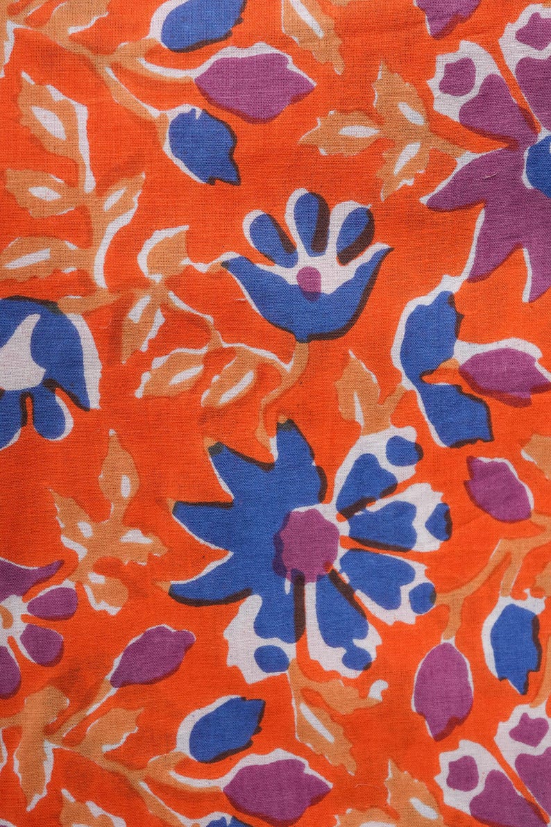 Modern and trendy women’s cotton lounge pants with eye-catching blue and purple floral patterns on a warm orange background – lightweight, soft jammies featuring elastic waistband, adjustable drawstring, and roomy pockets, great for casual lounging, pajama parties, and thoughtful 2nd anniversary gifts or cotton gift ideas for nature enthusiasts.