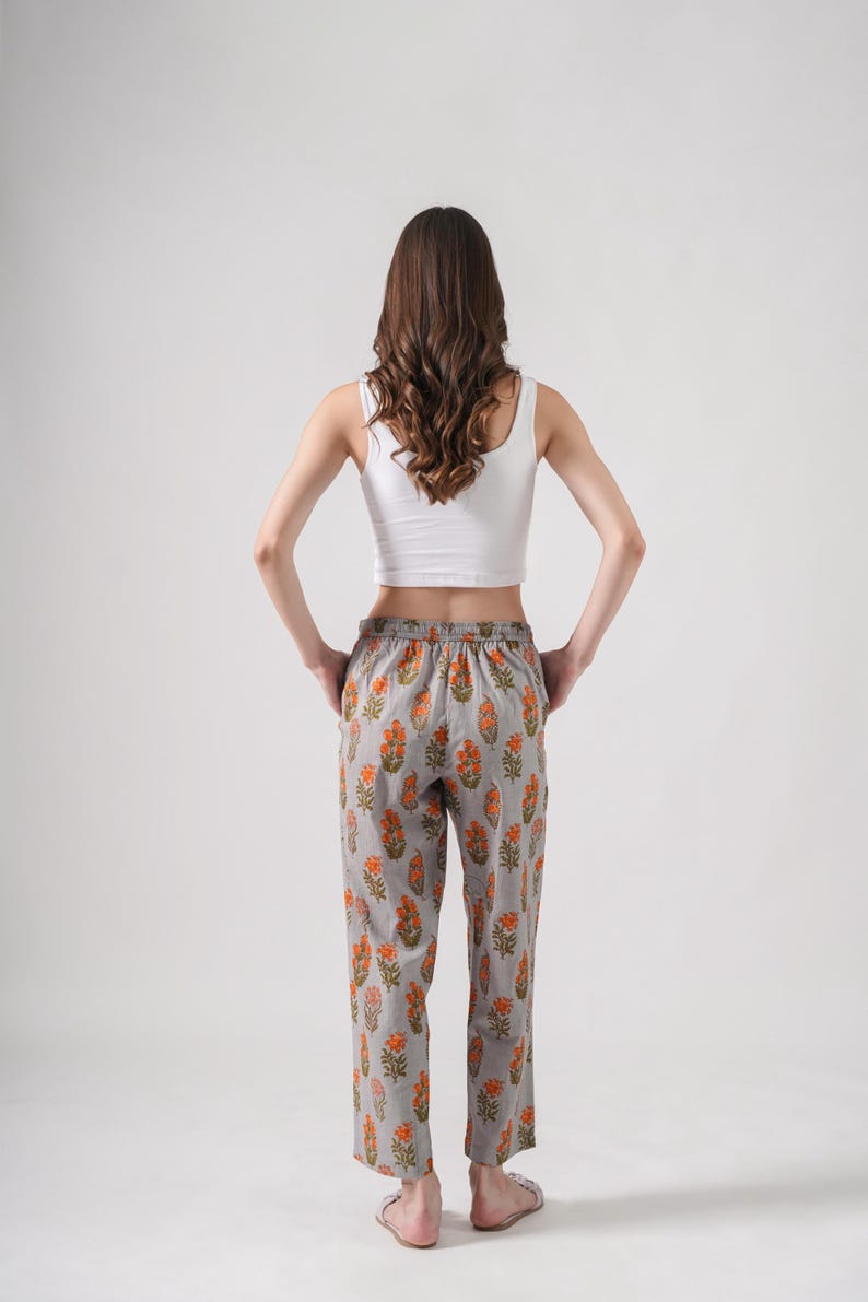Boho-inspired floral print lounge pants featuring soft gray cotton with bright orange flowers – handmade sleep trousers with elastic waist, drawstring closure, and pockets, ideal as stylish pj pants for reading, relaxing, or giving as gifts for book lovers, flower lovers, or self-care enthusiasts.