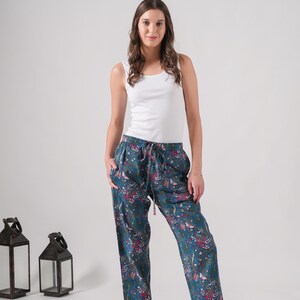 Casual cotton leggings-style lounge pants with elastic waist and deep pockets; colorful, tropical floral butterfly print on blue fabric—ideal gifts for meditation or traveler enthusiasts.