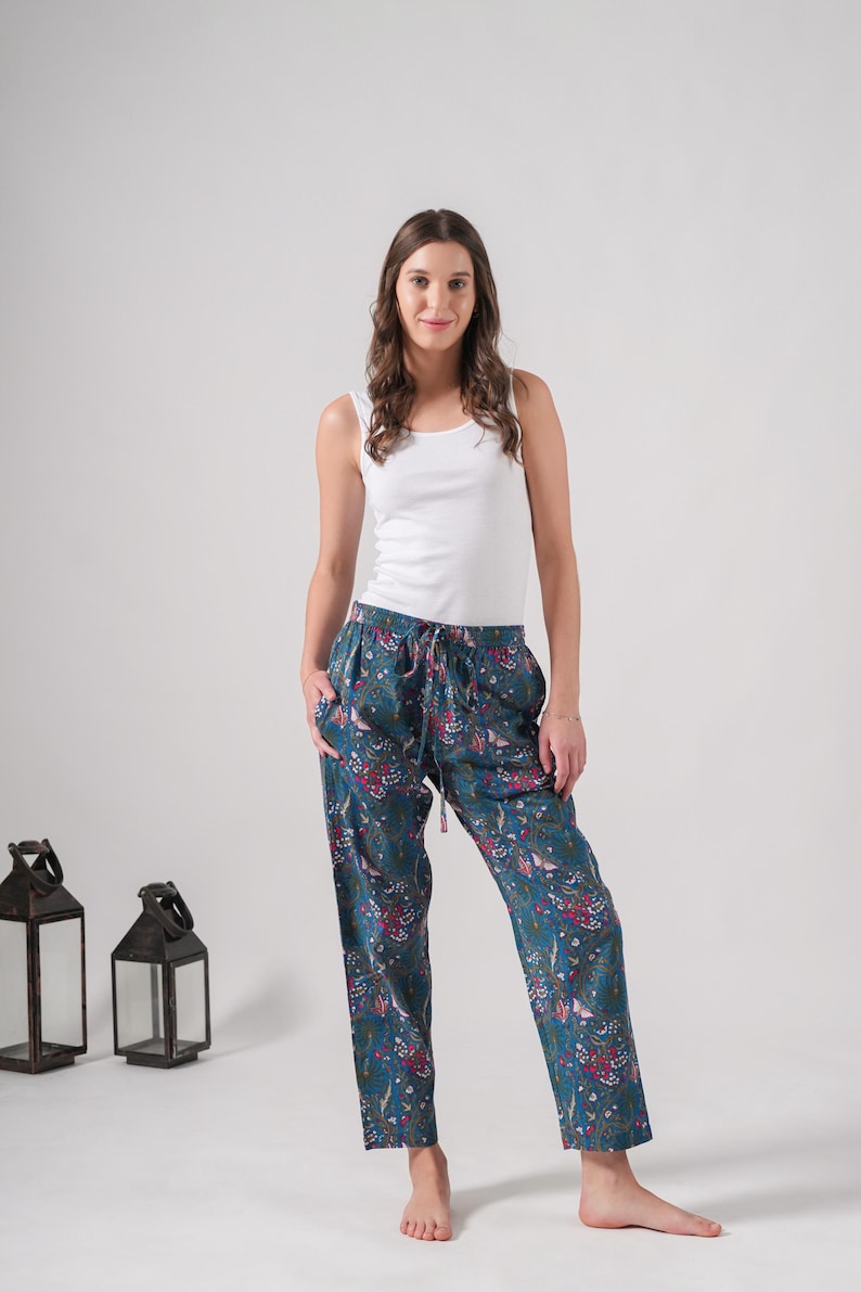 Casual cotton leggings-style lounge pants with elastic waist and deep pockets; colorful, tropical floral butterfly print on blue fabric—ideal gifts for meditation or traveler enthusiasts.