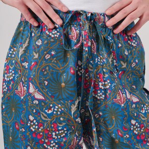 Lightweight boho cotton trousers with colorful pink flowers and butterflies print, elastic waistband, drawstring, and roomy pockets—perfect casual lounge and sleepwear for women.