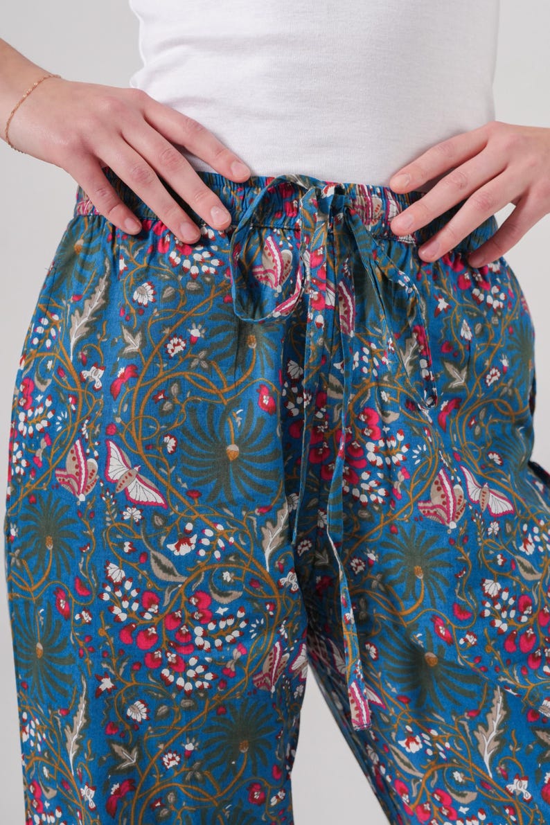 Lightweight boho cotton trousers with colorful pink flowers and butterflies print, elastic waistband, drawstring, and roomy pockets—perfect casual lounge and sleepwear for women.