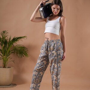 Soft, breathable 100% cotton pajama pants for women featuring vibrant orange floral prints on a muted gray background – relaxed fit pj pants with elastic waistband, adjustable drawstring, and deep pockets, perfect as lightweight sleep trousers, stylish lounge pants, or thoughtful menopause gift ideas and cotton anniversary gifts.