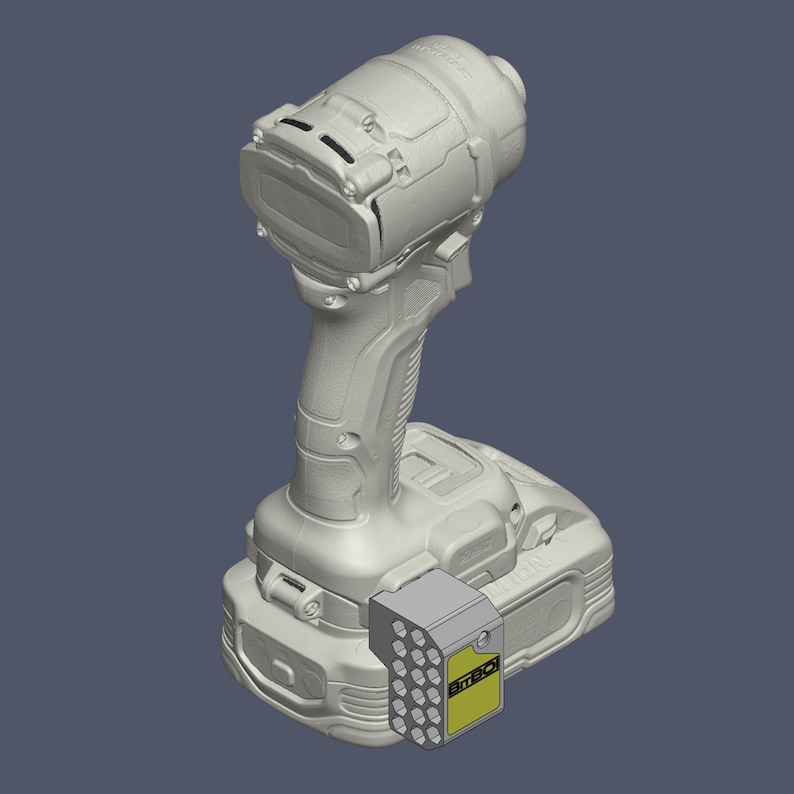 May include: A light grey cordless power drill featuring a textured handle and a battery pack base. Attached to the side of the battery is a rectangular grey bit holder with a yellow label containing the black text BITBO and a grid of circular holes.