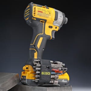 May include: A yellow and black cordless impact driver with a brushless motor and a 4Ah battery. Attached to the battery base is a black BitBoi bit holder containing a variety of metal screwdriver bits and sockets for professional power tool use.