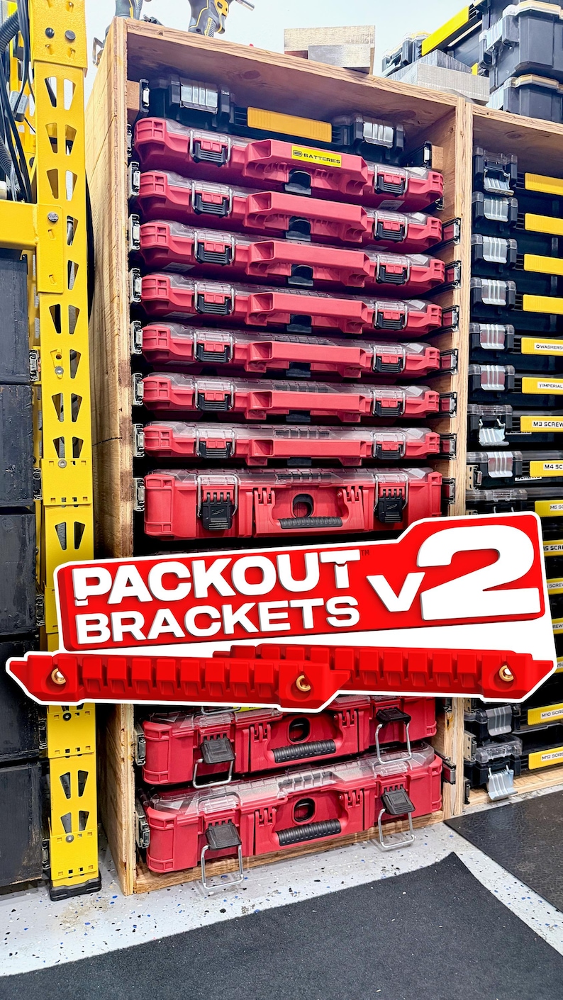 K&ouml;nnte beinhalten: Ein Holzregal mit mehreren roten und schwarzen Kunststoff-Werkzeugkoffern. Das Regal zeigt eine wei&szlig;e Grafik&uuml;berlagerung mit dem roten Text PACKOUT BRACKETS V2 sowie zwei rote Montagehalterungen, die vor der Lagereinheit platziert sind.