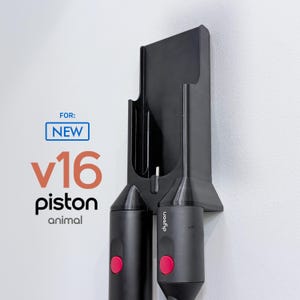 Può includere: Un supporto da parete nero per accessori aspirapolvere con due alloggiamenti. Il testo a sinistra recita FOR: NEW v16 piston animal. Il supporto è realizzato in materiale nero solido e include due accessori cilindrici con pulsanti rosa brillante.