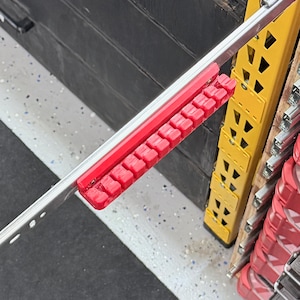 K&ouml;nnte beinhalten: Eine rote Steckschl&uuml;ssel-Organizerschiene aus Kunststoff mit zehn einzelnen Steckpl&auml;tzen zur Aufnahme von Steckschl&uuml;sseln, die sicher an einer silbernen Metall-Schubladenschiene befestigt ist. Die Basis hat erh&ouml;hte Trennw&auml;nde.