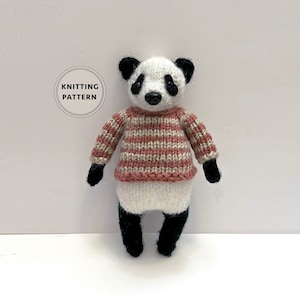 May include: Knitted panda bear toy wearing a striped sweater in pink and beige. The toy has black eyes, nose, and feet.
