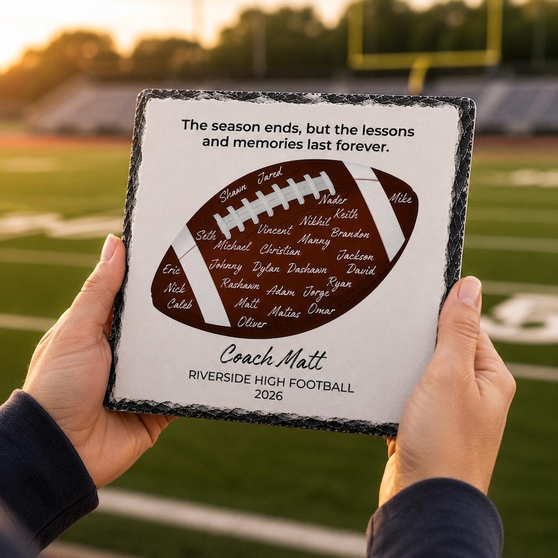 Puede incluir: Una placa de pizarra cuadrada con un borde oscuro y rugoso que presenta un gr&aacute;fico de bal&oacute;n de f&uacute;tbol americano marr&oacute;n en el centro. El bal&oacute;n contiene numerosos nombres escritos en blanco. El texto dice: The season ends, but the lessons and memories last forever. Coach Matt, RIVERSIDE HIGH FOOTBALL 2026.