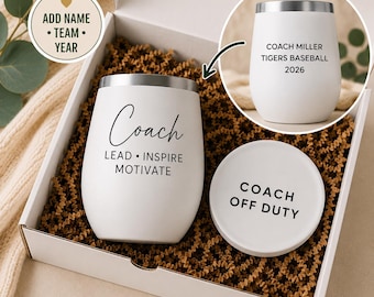 Puede incluir: Una copa de vino blanca sin tallo con borde plateado y la palabra "Coach" impresa, junto con "Lead, Inspire, Motivate". Un posavasos a juego dice "Coach Off Duty". La caja incluye una segunda copa con texto personalizado.