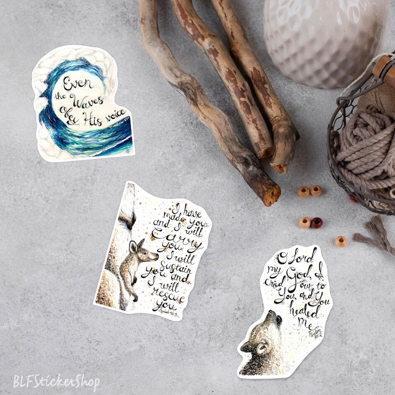 May include: Three watercolor stickers with inspirational quotes and illustrations. The first sticker features a blue wave with the text "Even the Waves obey His voice". The second sticker features a kangaroo with a joey and the text "I have made you and I will carry you. I will sustain you and I will rescue you". The third sticker features a wolf howling at the moon with the text "O Lord my God, I cried out to You and You healed me".