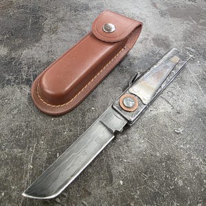 May include: A set of three ceramic mugs with a speckled, matte finish. Each mug features a different color: light blue, cream, and gray. The mugs have a simple, modern design with a rounded shape and a comfortable handle.