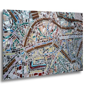 May include: A mosaic artwork featuring a colorful, abstract design composed of various shapes and sizes of tiles. The mosaic incorporates text elements, with phrases and words embedded within the artwork. The color palette includes shades of blue, green, brown, and white.