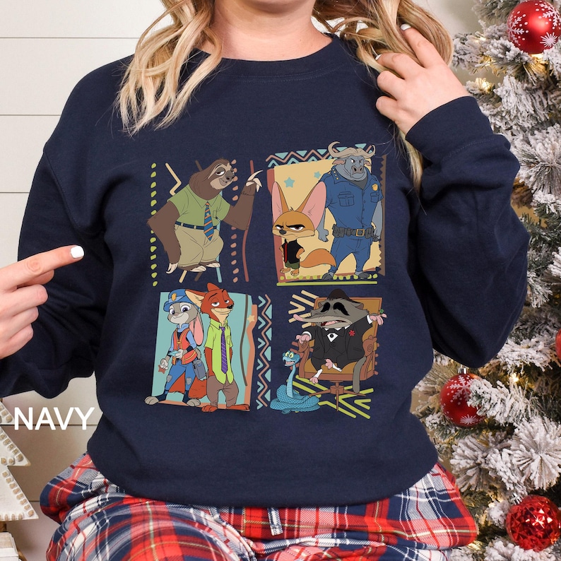 May include: Navy blue sweatshirt featuring a colorful graphic of characters from the animated movie Zootopia. The design includes images of a sloth, fox, bunny, and other characters. The word "NAVY" is printed on the bottom left.