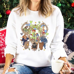 May include: White sweatshirt featuring a colorful cartoon image of animal characters in a heart-shaped frame. The design includes various animals in suits and uniforms, with stars and decorative elements. The word "WHITE" is printed on the bottom right.