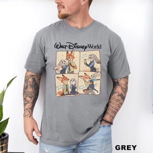 以下が含まれることがあります： 「ウォルト・ディズニー・ワールド」の文字が入った、4つのパネル漫画デザインのグレーのTシャツ。パネルには、さまざまなポーズをとるキツネとウサギが描かれています。「GREY」の文字が右下に印刷されています。