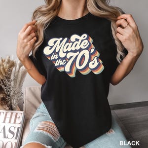 Puede incluir: Camiseta negra con un gr&aacute;fico de estilo retro que dice "Made in the 70's" en colores arco&iacute;ris.
