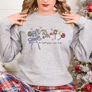 May include: Sport Grey sweatshirt featuring a whimsical design with cartoon characters and the text "You can be anything you wish to be." The design includes a mouse-eared hat, a fox, and a bow. The sweatshirt is a comfortable, casual style.