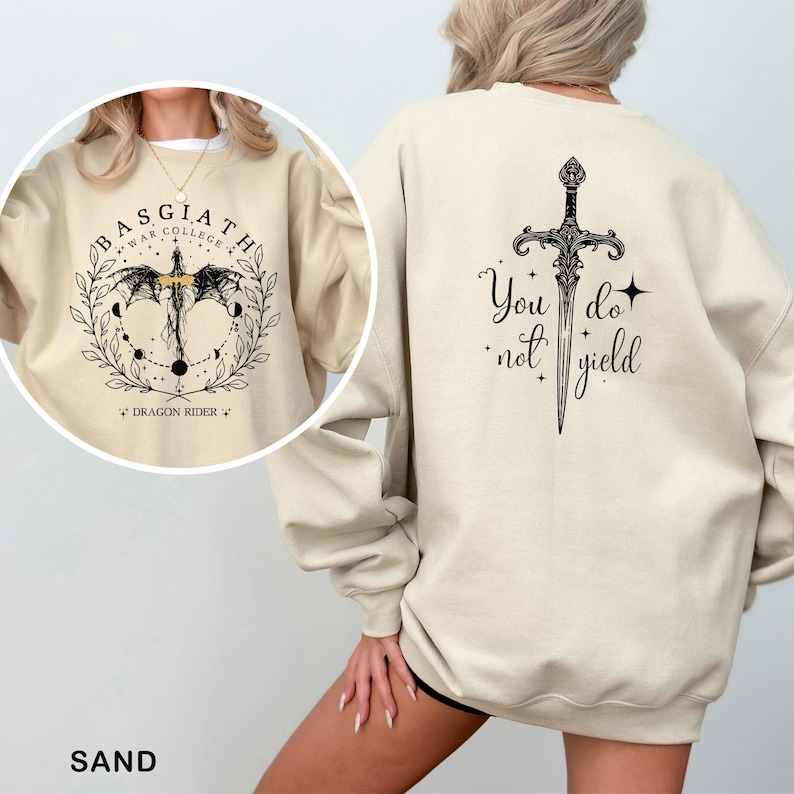 May include: Sand-colored sweatshirt with a black graphic on the front that says "BASGIATH WAR COLLEGE" and "DRAGON RIDER". The back features a sword design with the words "You do not yield".