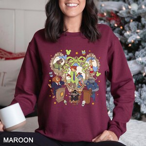 May include: Maroon sweatshirt featuring a cartoon illustration of various animal characters in a heart-shaped frame. The design includes characters in suits and uniforms, with the word "MAROON" at the bottom.