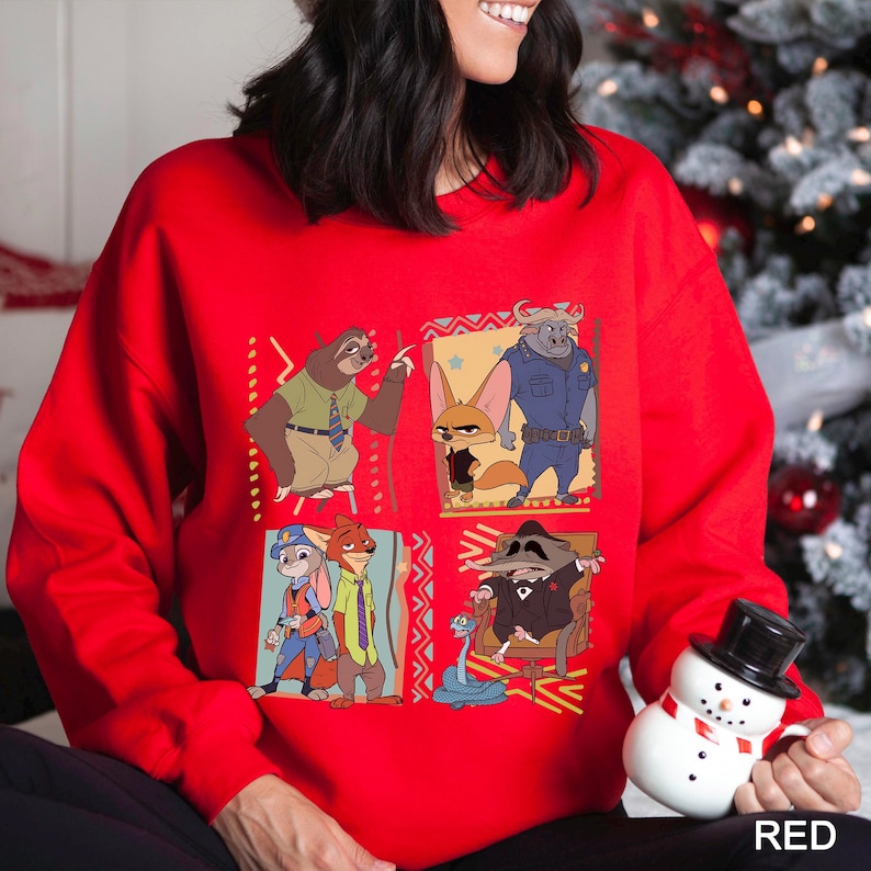 May include: A red sweatshirt featuring a colorful graphic of characters from the animated movie Zootopia. The design includes images of a sloth, fox, bunny, and other characters. The word "RED" is printed in white in the lower right corner.