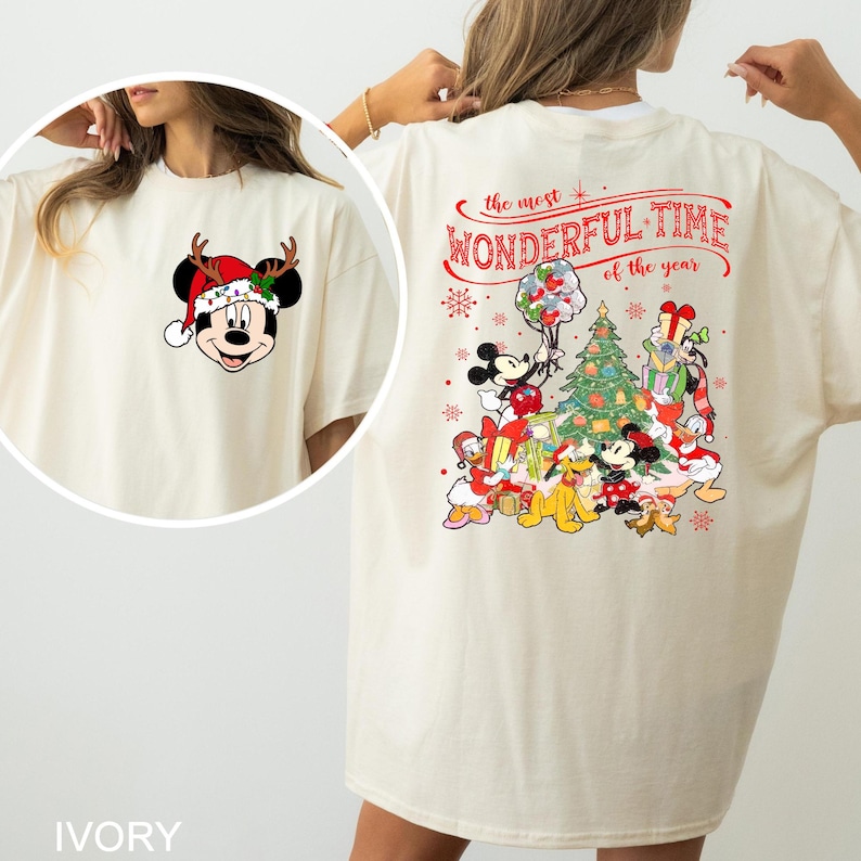 Puede incluir: Una camiseta blanca con un dise&ntilde;o navide&ntilde;o con Mickey Mouse y otros personajes de Disney. La parte delantera de la camiseta tiene una imagen de dibujos animados de Mickey Mouse con un gorro de Pap&aacute; Noel. La parte trasera de la camiseta tiene un dise&ntilde;o que dice "La &eacute;poca m&aacute;s maravillosa del a&ntilde;o" con Mickey Mouse, Minnie Mouse, Donald Duck, Goofy, Pluto y otros personajes reunidos alrededor de un &aacute;rbol de Navidad.