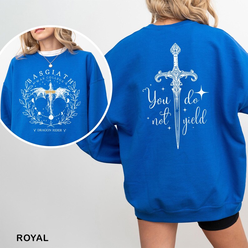 May include: Royal blue sweatshirt with white graphic designs. The front features text that reads "BASGIATH WAR COLLEGE" with a dragon and celestial elements. The back displays a sword design and the words "You do not yield."