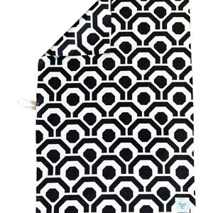May include: Black and white geometric patterned kitchen towel with a small white tag that says "Design by"