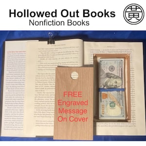 May include: A hollowed-out book with a hidden compartment containing a stack of $100 bills secured with a blue band. The book includes a wooden cover with the text "FREE Engraved Message On Cover". The book is labeled "Nonfiction Books".