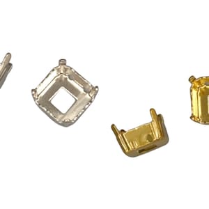 May include: Four metal jewelry settings in silver and gold tones. Each setting has a square opening in the center and four prongs. The settings are designed to hold gemstones or other decorative elements.