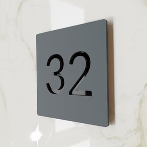 Könnte beinhalten: Ein rechteckiges graues Schild mit der Nummer 32, die in der Mitte ausgeschnitten ist.