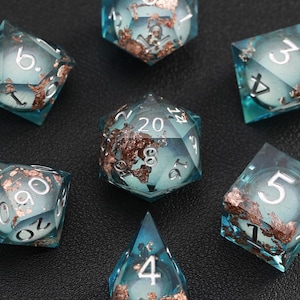 May include: Set of seven polyhedral dice with a teal and copper design. The dice are transparent with white numbers and copper-colored accents. The dice are arranged on a dark surface.